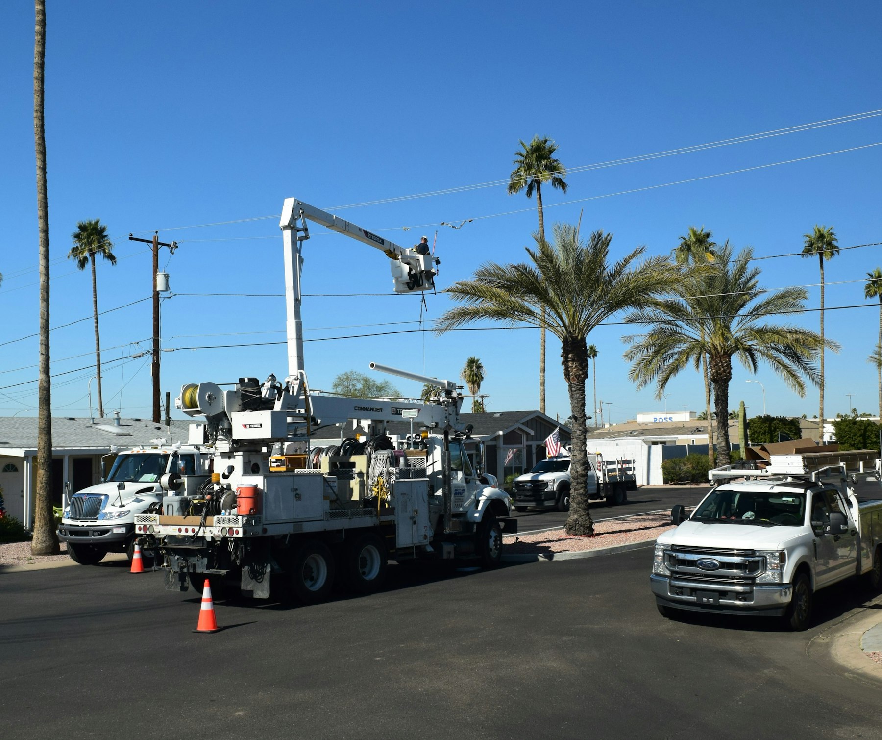 Boom trucks and Ford Super Duty work trucks under palm trees