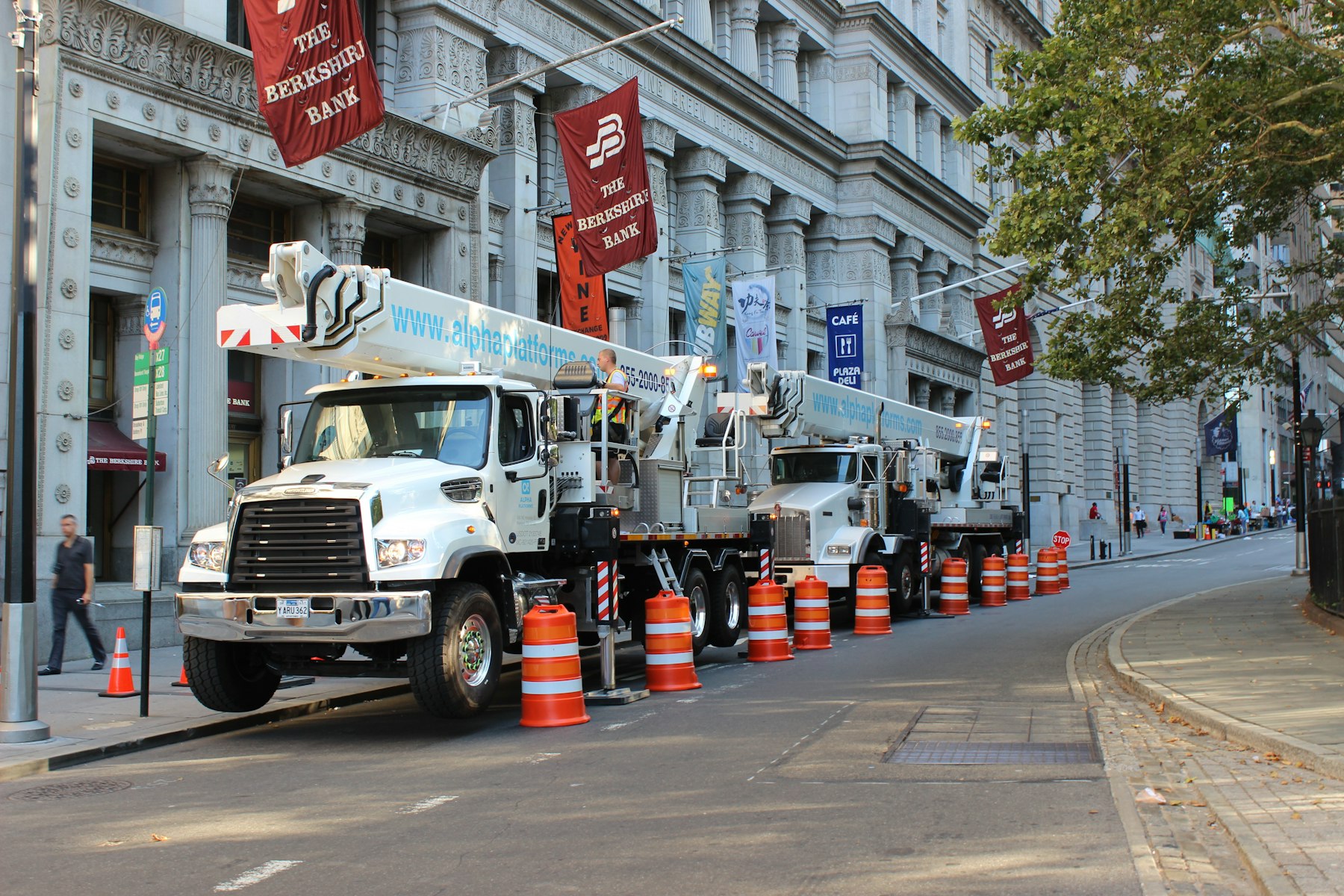 Boom truck cranes lined up on a city street