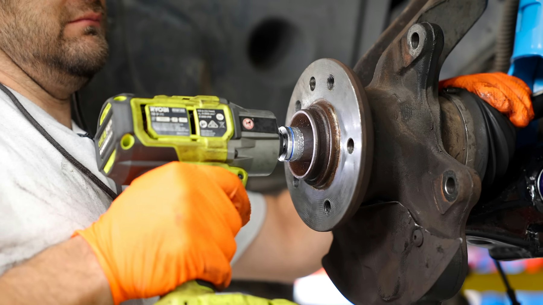 Mechanic removing a wheel hub with an impact wrench